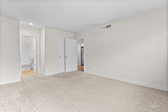 an empty living room with white walls and carpet