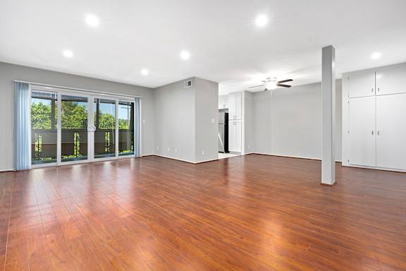 A room with wooden floors and a ceiling fan.