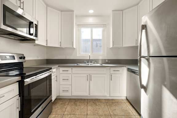 A kitchen with white cabinets and stainless steel appliances.