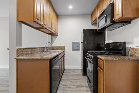 a kitchen with black appliances and wooden cabinets at Parkview Terrace Apartments, Sherman Oaks, 91423