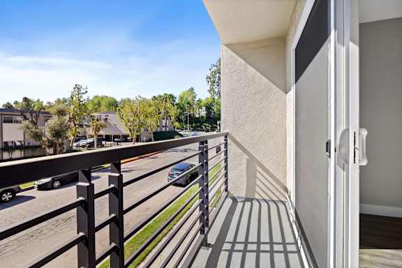A balcony with a black railing and a white door.