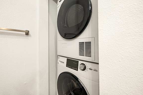 A white washing machine is installed in a wall.