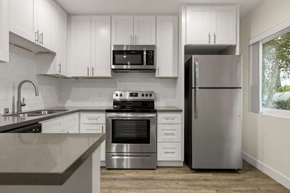 A modern kitchen with stainless steel appliances and white cabinets.