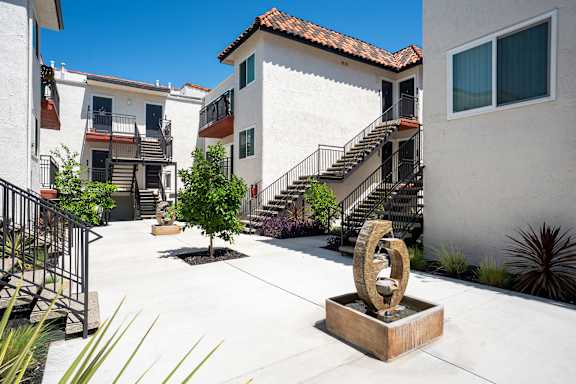 A courtyard with a sculpture in the middle of it.