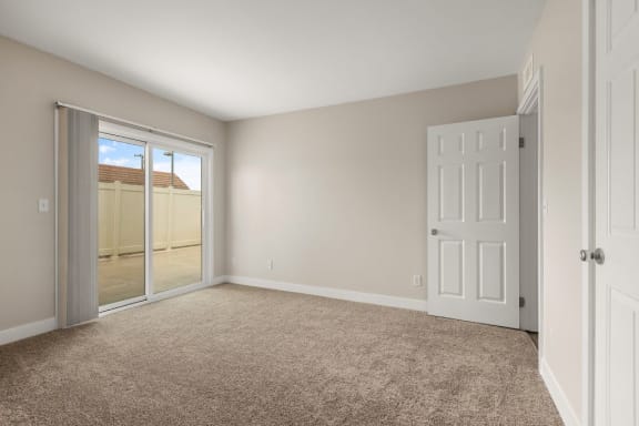 an empty bedroom with a door to a patio