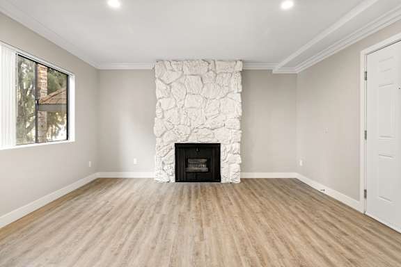 A room with a fireplace and wooden floors.