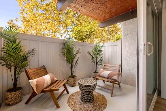 A patio with a wooden chair and table.