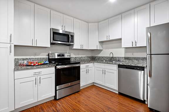 A kitchen with white cabinets and stainless steel appliances.