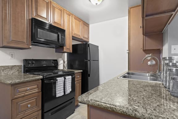 a kitchen with black appliances and granite counter tops