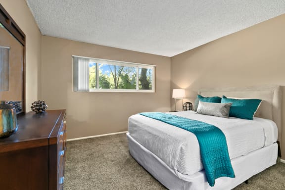 a bedroom with a bed and a dresser and a window