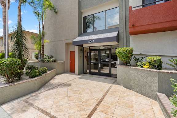 A building with a red door and a black awning at Woodland Trio Apartments, California, 91601