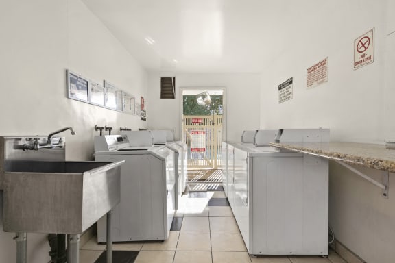 the laundry room is equipped with stainless steel washers and dryers