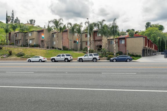 a row of apartment buildings on the side of a street