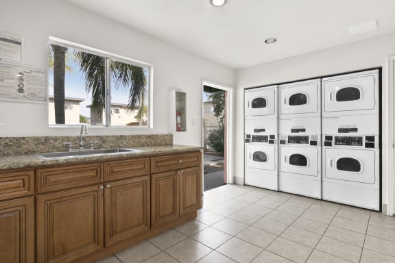 a white laundry room with a sink and washer and dryer