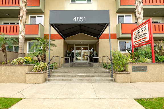 The entrance to apartment building 4851 with a red sign on the right.