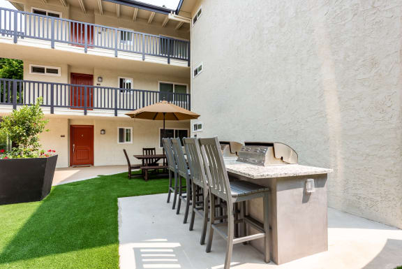 a bar with chairs and a grill on a patio