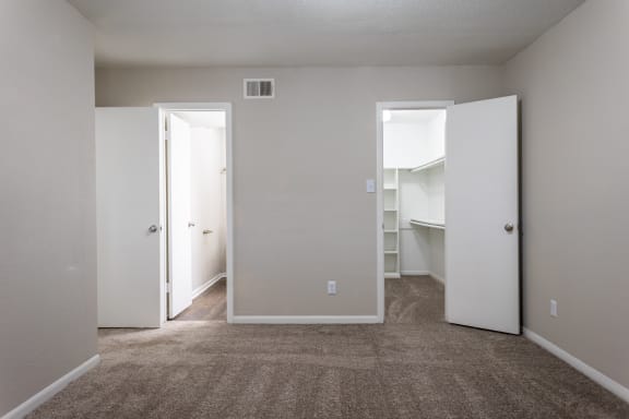 a bedroom with a carpeted floor and a closet with two doors