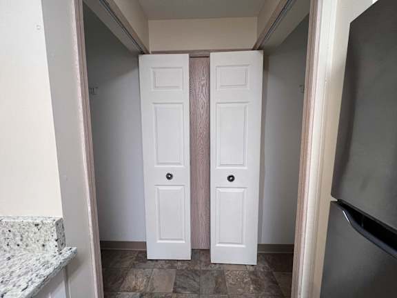 A white door with a black handle is in a hallway.
