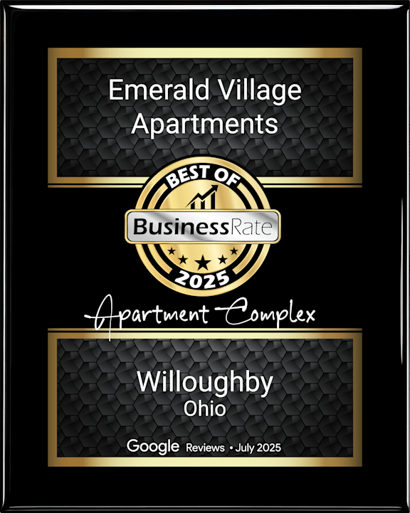 A black and gold award frame for Emerald Village Apartments from Business Rate 2025.