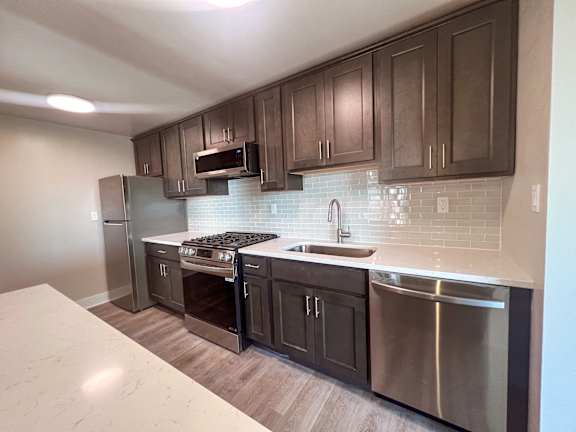 a kitchen with stainless steel appliances and wooden cabinets at Huntington Green Apartments, University Heights, Ohio