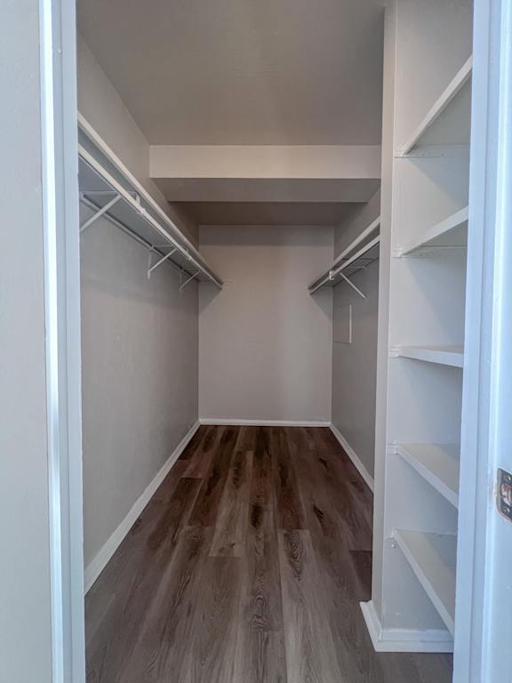 a walk in closet with shelves and a wood floor at Huntington Green Apartments, University Heights, OH