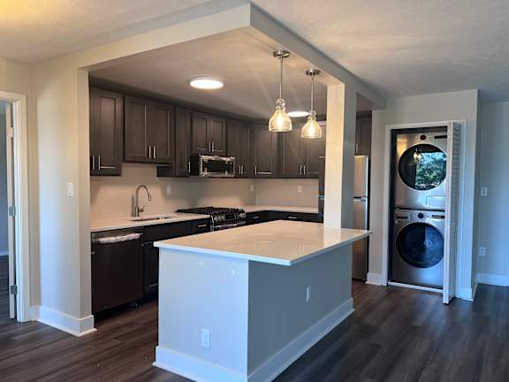 a kitchen with an island and a washer and dryer at Huntington Green Apartments, University Heights, OH