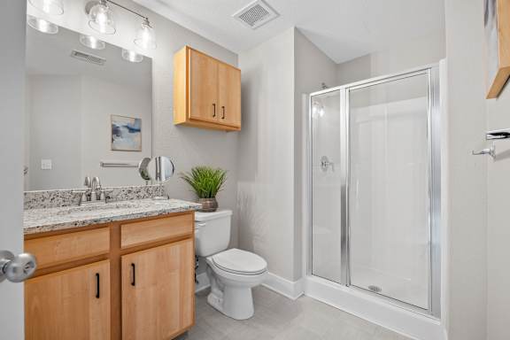 A bathroom with a toilet, sink, and shower.