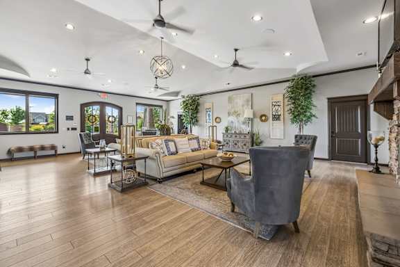 A spacious living room with a grey sofa and wooden flooring.