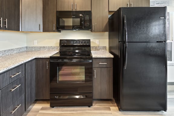 Kitchen With Granite Countertops & Black Microwave