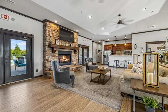 A modern living room with a stone fireplace and a flat screen TV mounted above it.
