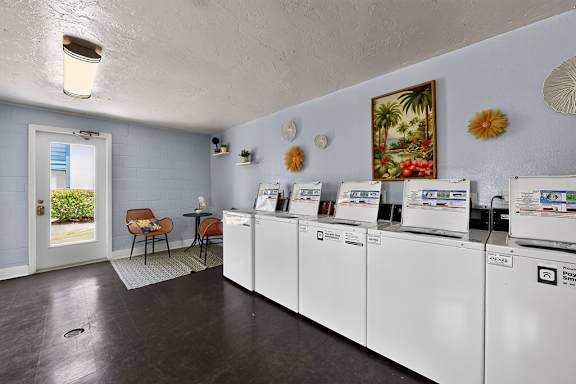 A laundry room with a washer and dryer on the wall.