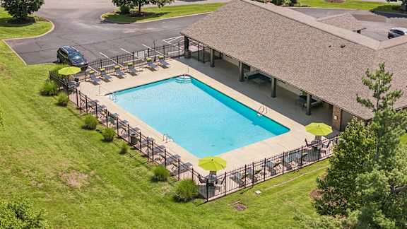A large outdoor swimming pool surrounded by a metal fence.