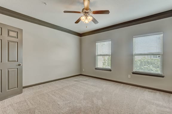 Spacious Carpeted Bedroom With Ceiling Fan & Light