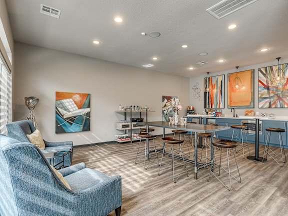 A living room with a blue chair and a dining table.