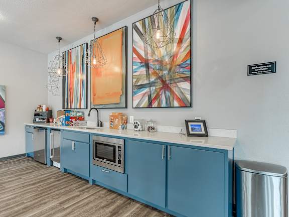 A kitchen with blue cabinets and a wooden floor.