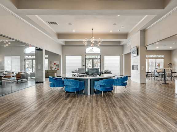 A modern office space with blue chairs and wooden floors.