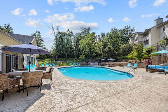 A large outdoor swimming pool surrounded by lounge chairs and umbrellas.