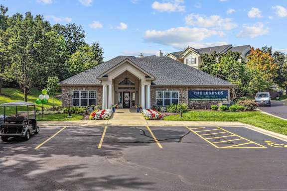 A building with a sign that says "The Legends" is surrounded by a parking lot.