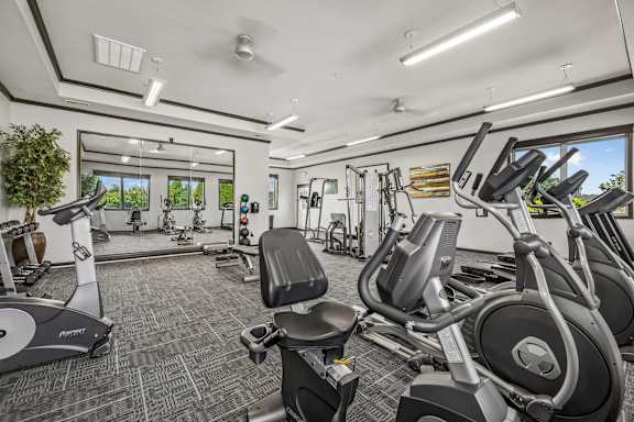 A gym with treadmills, exercise bikes, and weights.