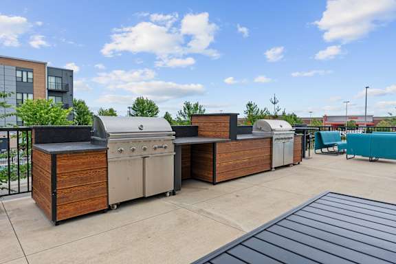 A patio with a grill and a table.