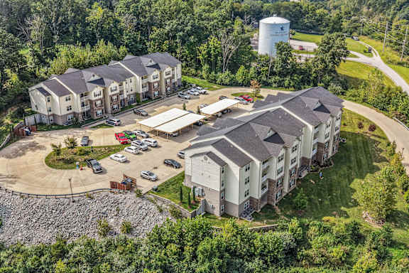 A large building complex with a parking lot in front.