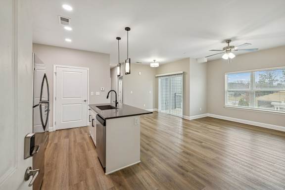 A modern kitchen with wooden floors and white walls.