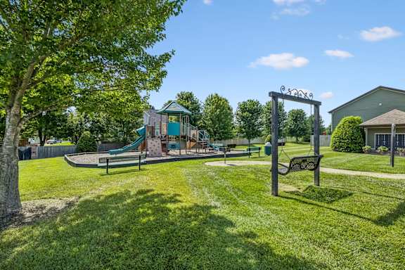 A playground with a swing set and a slide in a grassy area.