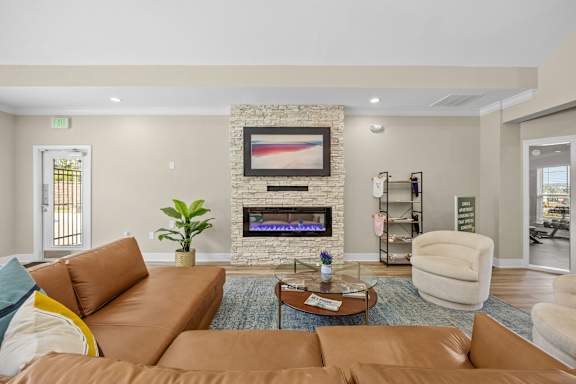 A living room with a brown couch and a fireplace.