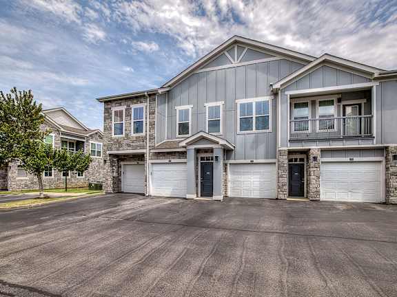 A large house with a grey exterior and a garage.