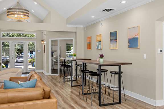 A modern living room with a bar area and a view of the street outside.
