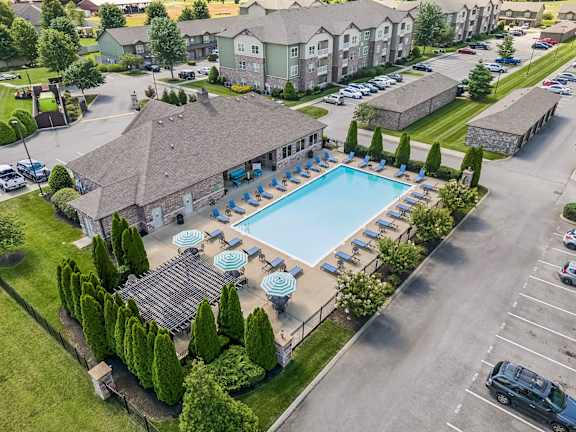 An aerial view of a resort with a swimming pool and parking lot.