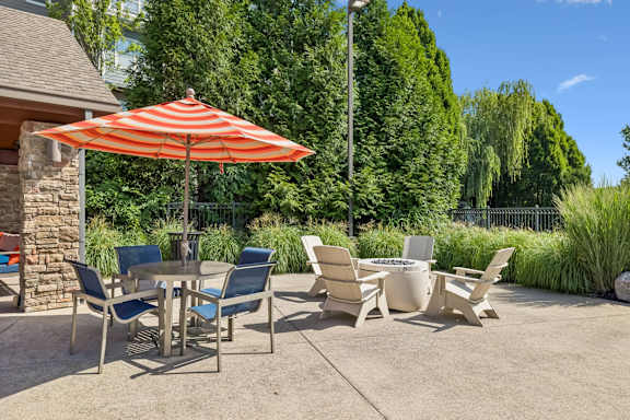 A patio with a table and chairs under an umbrella.