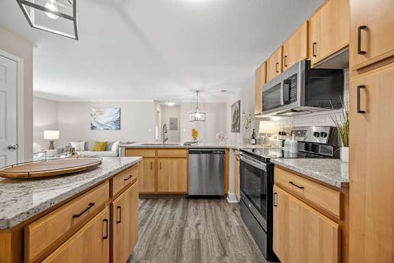 A kitchen with wooden cabinets and a marble countertop.