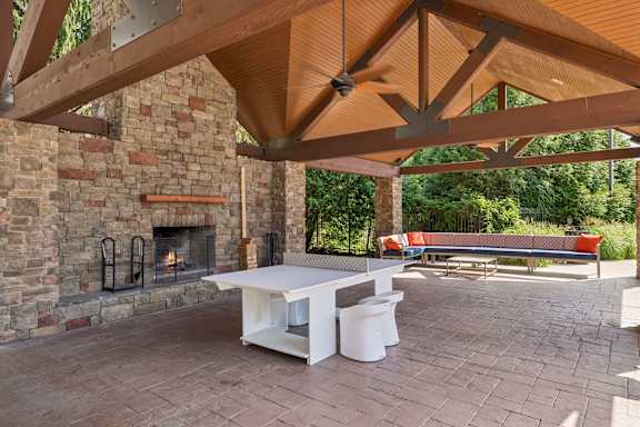 A patio with a fireplace and a table.